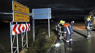 Die Feuerwehrleute sehen sich die Spuren im Kreuzungsbereich an.