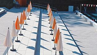 Noch stehen die Sonnenschirme in Reih und Glied, wartend auf die Badegäste. Bereits lange bevor die ersten Schwimmer eintreffen, haben die Angestellten des Freibades einiges zu erledigen.