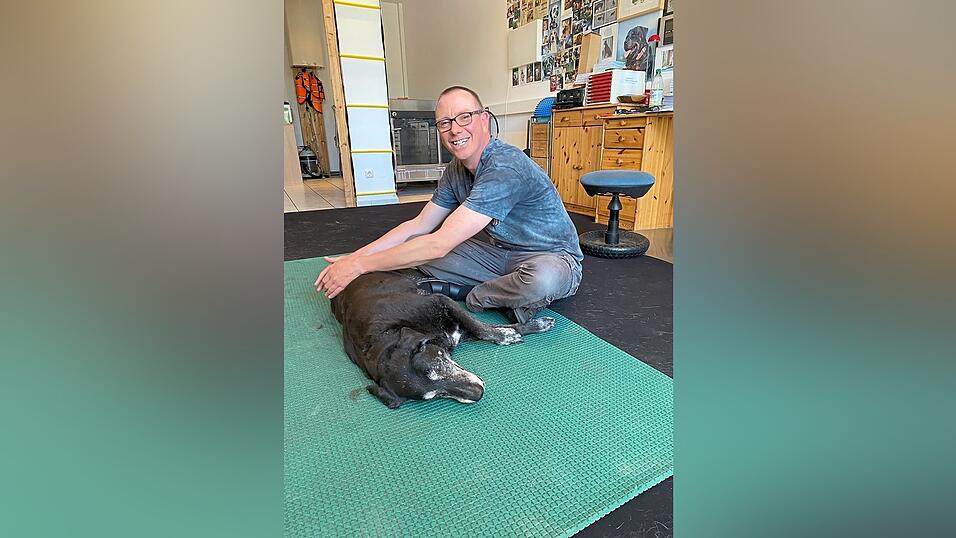 Das Bild zeigt Franz Schmalzgruber bei der Physiotherapie mit Patienten-Hündin Chica. Das Bild zeigt Franz Schmalzgruber bei der Physiotherapie mit Patienten-Hündin Chica.