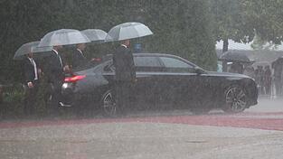 Ministerpr&auml;sident Markus S&ouml;der und Ehefrau Karin S&ouml;der warten vor der Er&ouml;ffnung bei Regen im Auto.