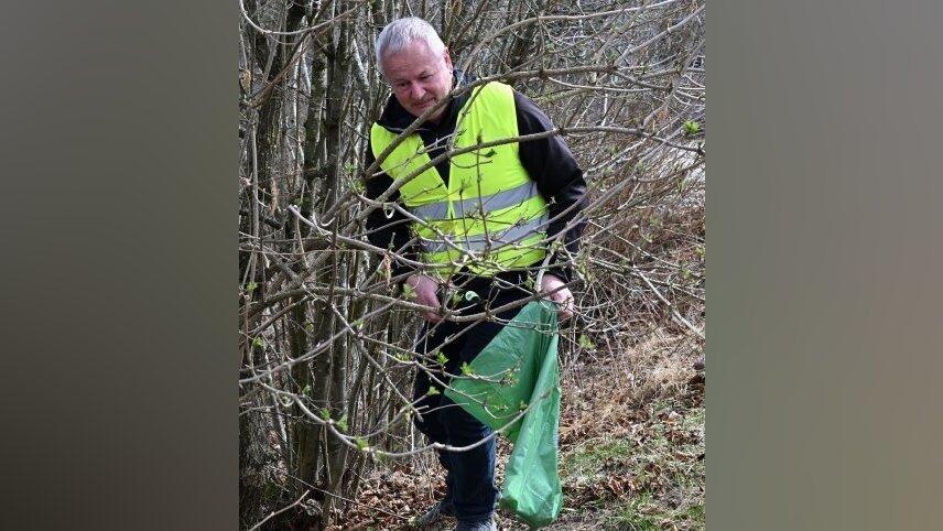 B&uuml;rgermeister Anton Piermeier sammelt im Geb&uuml;sch Pfandflaschen auf.