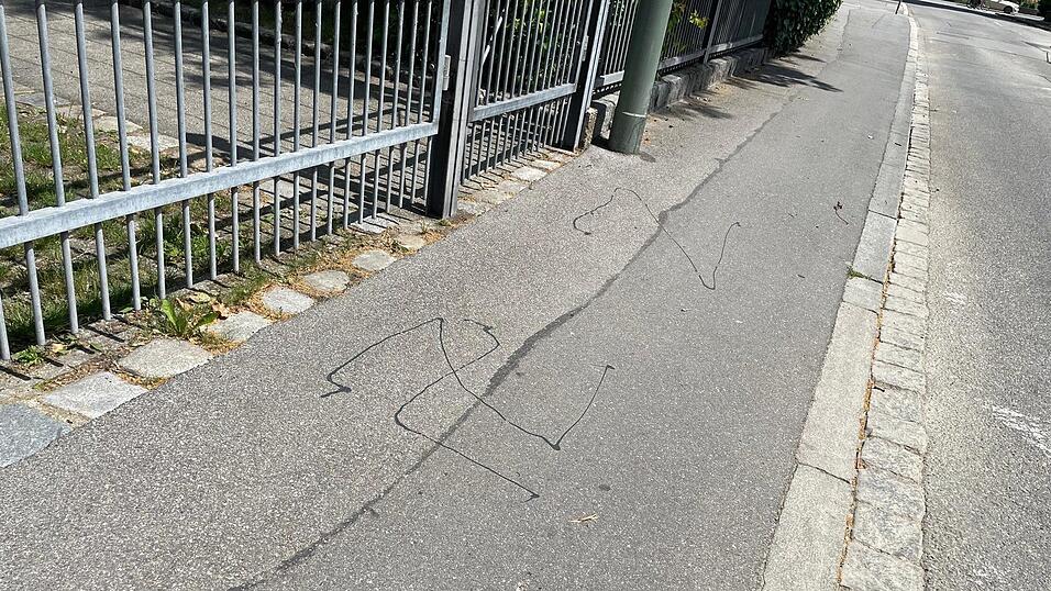 Aus Bitumenmasse, wie sie zum Verfugen bei Stra&szlig;en verwendet wird, hat der T&auml;ter vor l&auml;ngerer Zeit die verbotenen Symbole auf den Gehweg geschmiert. Gek&uuml;mmert hat es bislang niemanden.