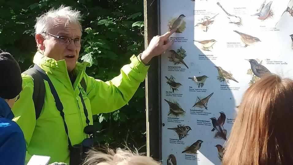 Exkursionsleiter Franz Meindl erl&auml;utert die Vogelarten auf der Infotafel.