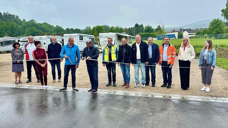 Mit dem obligatorischen Bandschnitt er&ouml;ffnete B&uuml;rgermeister Sandro Bauer zusammen mit Alexander Voss (beide in der Mitte) offiziell den neuen Stellplatz f&uuml;r Wohnmobile an der Jettingerstra&szlig;e.