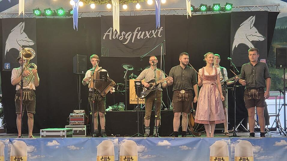 Pfingstbr&auml;utigam Benedikt Aschenbrenner (r.), Pfingstbraut Romy Weindl (3. v. r.) und Brautf&uuml;hrer Maximilian Steidl (4. v. r.) aus Bad K&ouml;tzting dirigieren &bdquo;Ausgfuxxt&ldquo; am Montagabend auf der Festzeltb&uuml;hne.