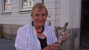 Seit mehr als 30 Jahren stellt Elisabeth Cramer-Guggemos Silberkreuze her. Das Bild zeigt die 84-J&auml;hrige Veldenerin vor der Vilsbiburger Volkshochschule, in der sie 30 Jahre lang Kurse gab. Das Kreuz hat sie f&uuml;r ihre Schwiegermutter Sophie Cramer gefertigt.