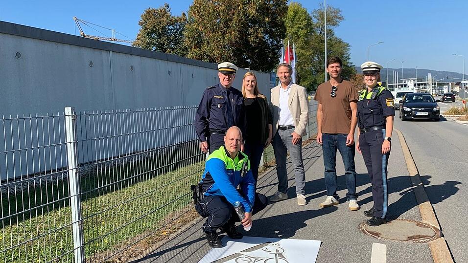 Start frei für die Geisterradler-Aktion von Polizei, Stadt Deggendorf und Kreisverkehrswacht: Ab sofort machen an der Graflinger Straße Piktogramme Radfahrer darauf aufmerksam, dass sie in falscher Richtung unterwegs sind. Weitere grafische Darstellungen an anderer Stelle folgen. Von links: POK Andreas Pilsl (kniend), PD Markus Völkl, Ordnungsamtsleiterin Elisabeth Aigner, Heinz Schott von der Kreisverkehrswacht, Mobilitätsmanager Simon Renner und Polizeipressesprecherin Johanna Vogl. Start frei für die Geisterradler-Aktion von Polizei, Stadt Deggendorf und Kreisverkehrswacht: Ab sofort machen an der Graflinger Straße Piktogramme Radfahrer darauf aufmerksam, dass sie in falscher Richtung unterwegs sind. Weitere grafische Darstellungen an anderer Stelle folgen. Von links: POK Andreas Pilsl (kniend), PD Markus Völkl, Ordnungsamtsleiterin Elisabeth Aigner, Heinz Schott von der Kreisverkehrswacht, Mobilitätsmanager Simon Renner und Polizeipressesprecherin Johanna Vogl.