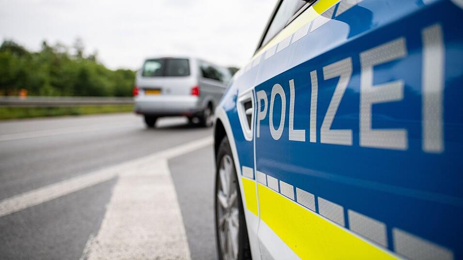 Ein Streifenwagen der Polizei steht auf einer Stra&szlig;e.