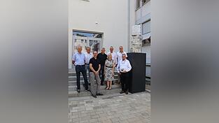 Rupert Buchner vom Hochbauamt (v.l.), Baureferent Oliver Vetter-Gindele, Hochbauamtsleiter Marko Kreißig, stellvertretender Landrat Ludwig Knott, Hermine Eckl, Leiterin der Staatlichen Berufsschule I, OB Markus Pannermayr, Kultur-Verwaltungsrat Andreas Fuchs und Künstler Markus Eberl neben dem Kunstwerk „Kompression“ - in Erinnerung an Josef Eberl, 2026, Aluminium. Rupert Buchner vom Hochbauamt (v.l.), Baureferent Oliver Vetter-Gindele, Hochbauamtsleiter Marko Kreißig, stellvertretender Landrat Ludwig Knott, Hermine Eckl, Leiterin der Staatlichen Berufsschule I, OB Markus Pannermayr, Kultur-Verwaltungsrat Andreas Fuchs und Künstler Markus Eberl neben dem Kunstwerk „Kompression“ - in Erinnerung an Josef Eberl, 2026, Aluminium.