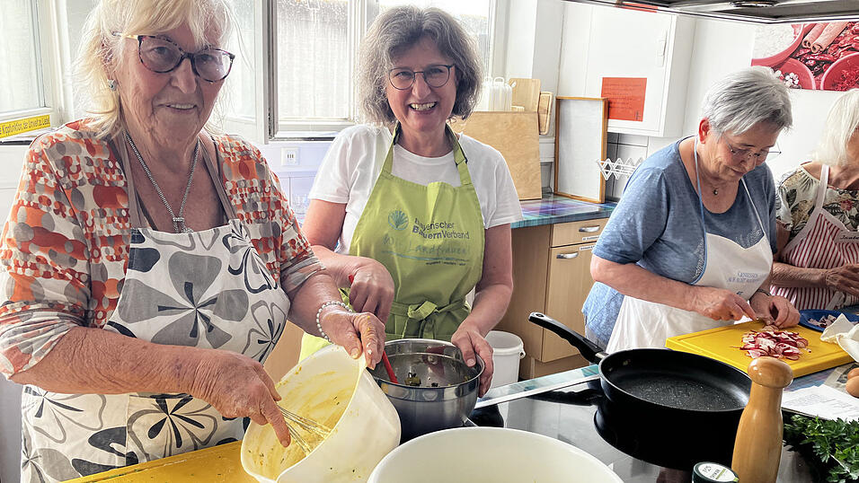 Kursleiterin Ingrid Lokotsch (2.v.l.) bereitet die Rezepte vor, kauft regionale Zutaten ein und unterst&uuml;tzt die Teilnehmer beim Kochen. Alle haben sichtlich Spa&szlig; dabei.
