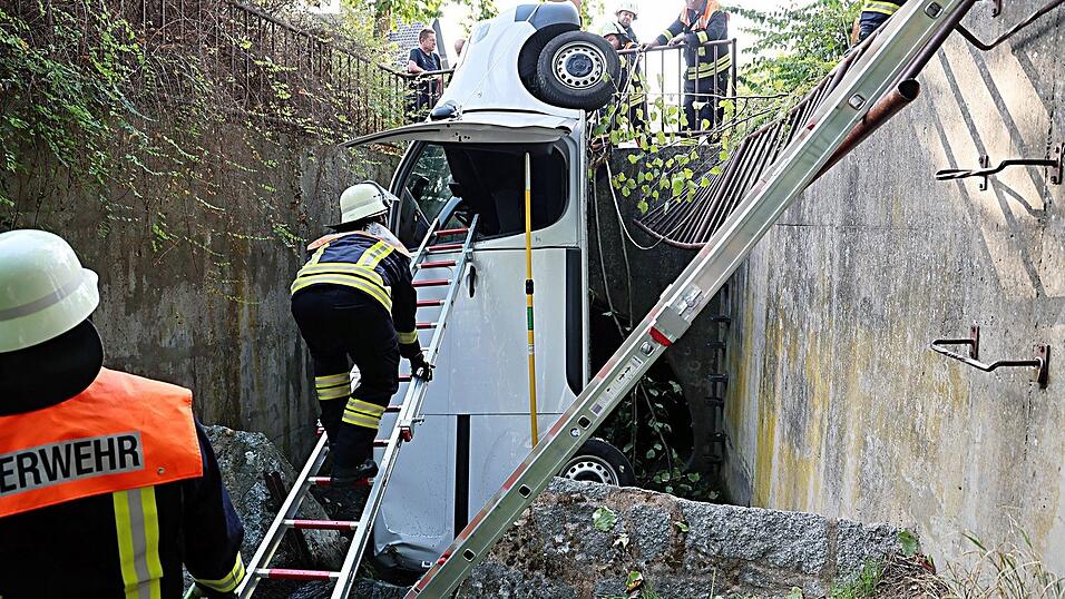 Ein Transporter durchbricht ein Metallgeländer und landet senkrecht im Bach. Ein Transporter durchbricht ein Metallgeländer und landet senkrecht im Bach.