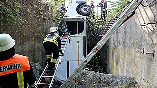 Ein Transporter durchbricht ein Metallgeländer und landet senkrecht im Bach. Ein Transporter durchbricht ein Metallgeländer und landet senkrecht im Bach.