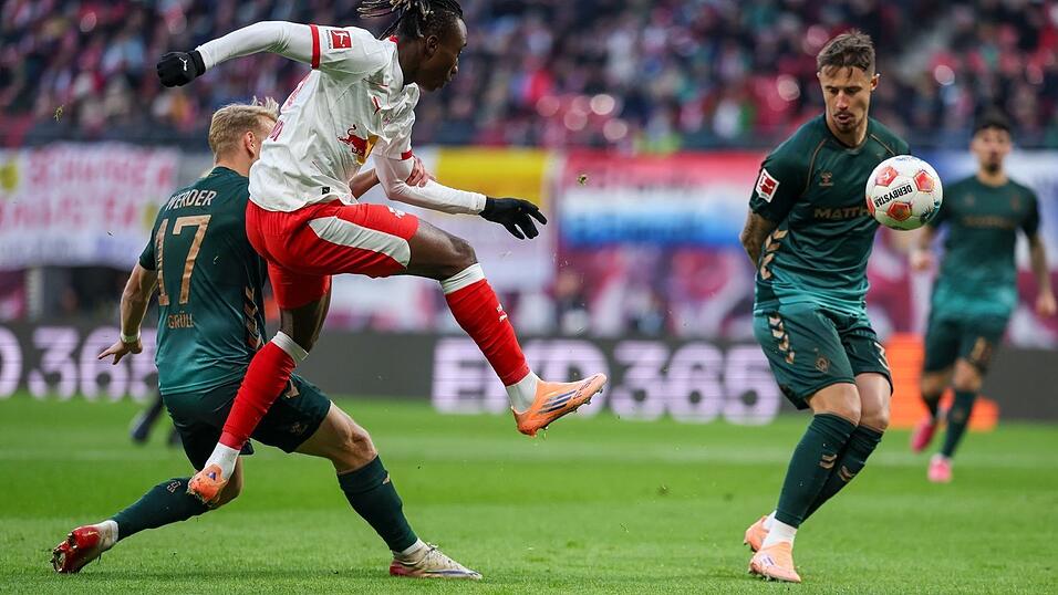 Yan Diomandé (M, RB Leipzig), Marco Grüll (l, Werder Bremen) und Marco Friedl (Werder Bremen) kämpfen um den Ball.