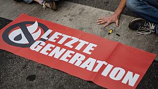 Ein Aktivist der Gruppe «Letzte Generation» blockiert eine Kreuzung.