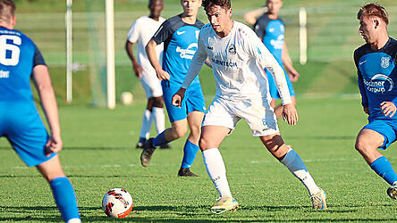 Der TSV Bogen um Noah Winter (in Weiß) landet beim FC Teisbach (in Blau) einen überzeugenden 2:0-Auswärtssieg.