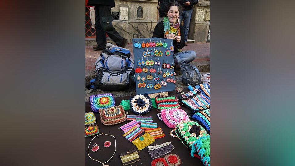 Cecilia verkauft selbstgehäkelte Taschen und Accessoires auf dem Künstlermarkt in Buenos Aires. (Foto: Lena Klimkeit/dpa)