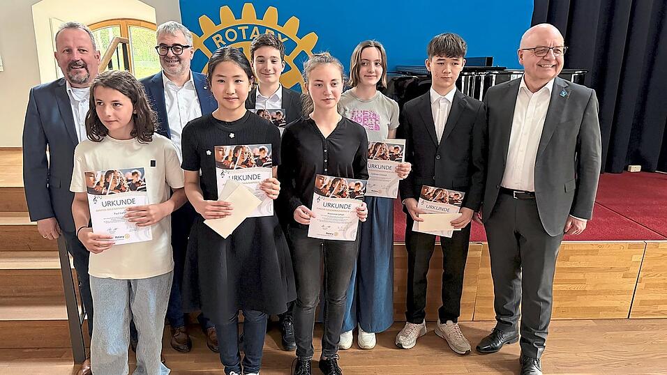 Die Rotary-Preistr&auml;ger Lisa Zou (vorne 2. v.l.), Anastasiia Lytvyn (vorne 3.v.l.), Francesco Baric (hinten 3.v.l.) und Collin Stanglmeier (hinten 2.v.r.) spielten das Abschlusskonzert im Zehentstadl. Auf dem Bild alle Preistr&auml;ger mit Moderator Hartmut Brau&szlig; (li), Rotary Pr&auml;sident Albert Stuber und District Governor Ulli Kersting (re).