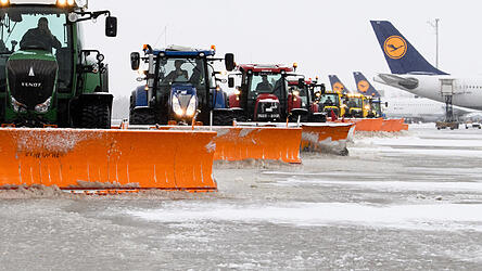 Versetzt fahrende Traktoren mit R&auml;umschildern befreien am Terminal 2 am Flughafen M&uuml;nchen das Vorfeld von Schnee. Mit dem Wintereinbruch in der letzten Woche war der Airport offenbar &uuml;berlastet.