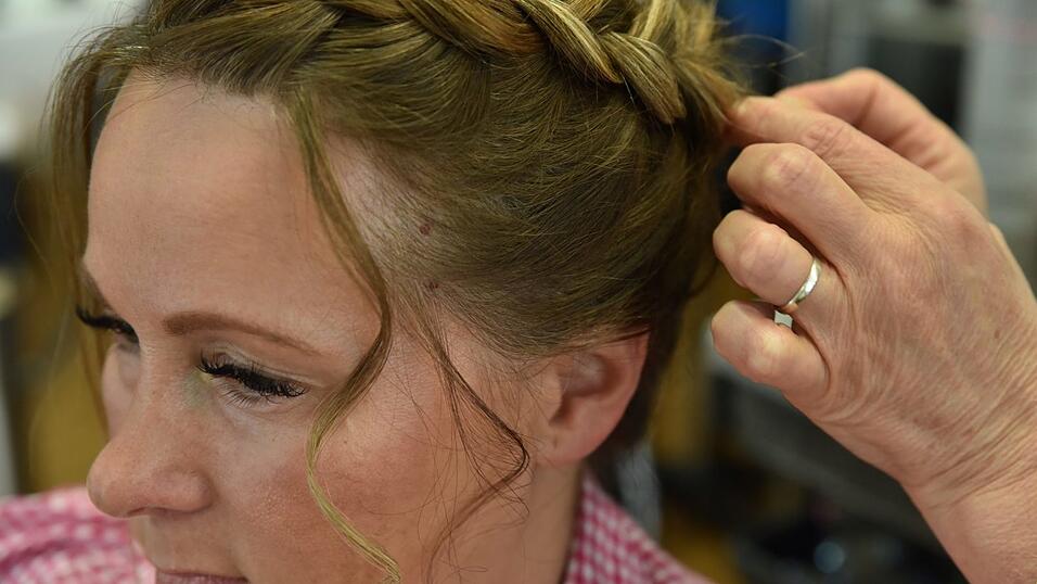 Der Zopf wird nun zu einem Dutt zusammengerollt und mit Haarklammern fixiert. Der Zopf wird nun zu einem Dutt zusammengerollt und mit Haarklammern fixiert.