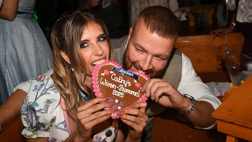 Cathy Hummels und Rapper Kollegah fassen sich bei Hummels Wiesn-Bummel ein Herz.