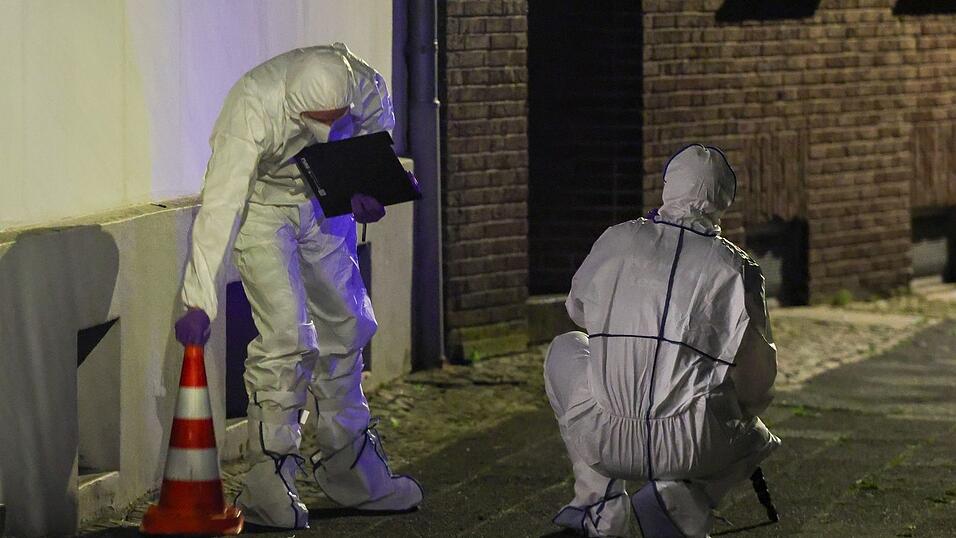 Beamte der Spurensicherung in Spurensicherungsanzügen begutachten den Tatort. Beamte der Spurensicherung in Spurensicherungsanzügen begutachten den Tatort.