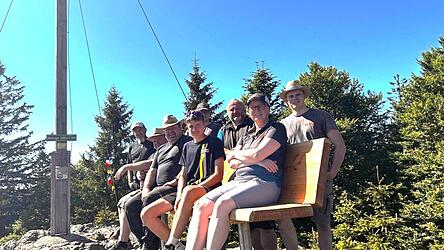 Verdiente Rast nach harter Arbeit: Das Team des Arnbrucker Wald-Vereins auf der neuen Ruhebank oben auf dem M&uuml;hlriegel.