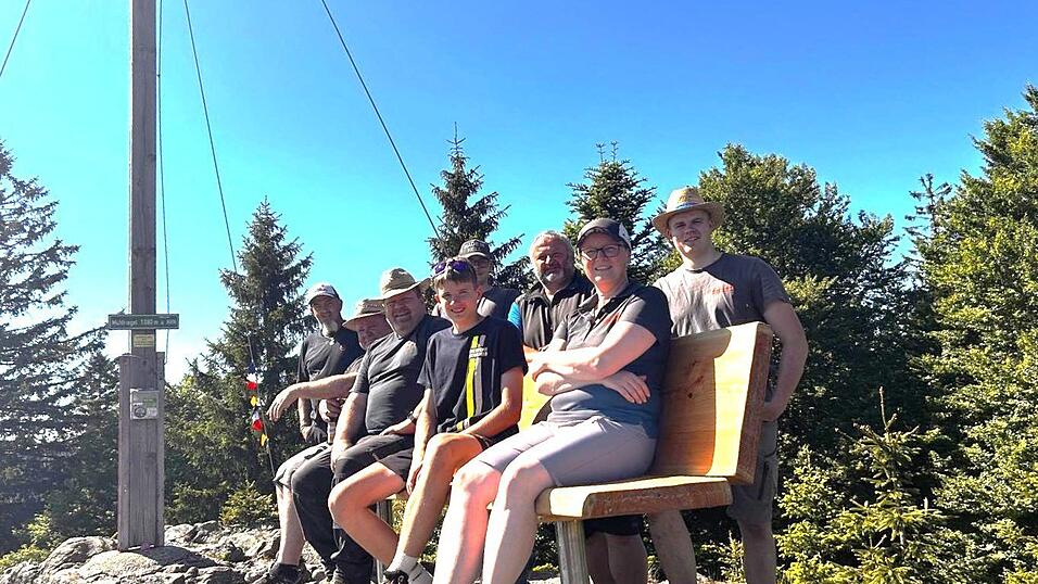 Verdiente Rast nach harter Arbeit: Das Team des Arnbrucker Wald-Vereins auf der neuen Ruhebank oben auf dem M&uuml;hlriegel.