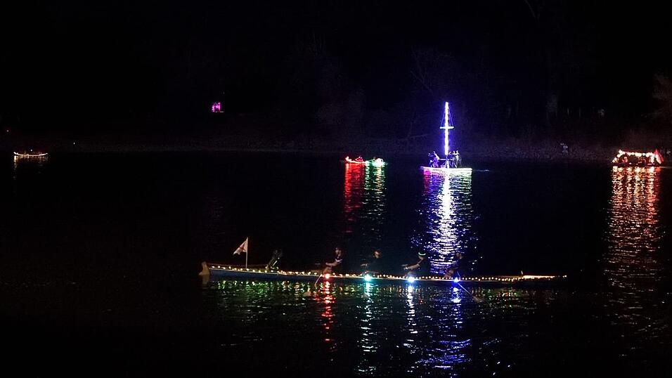 Bunt beleuchtete Boote fahren bei der Lampionfahrt über die Donau.