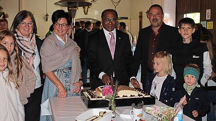 Der Pfarrer schneidet die Jubiläumstorte an.