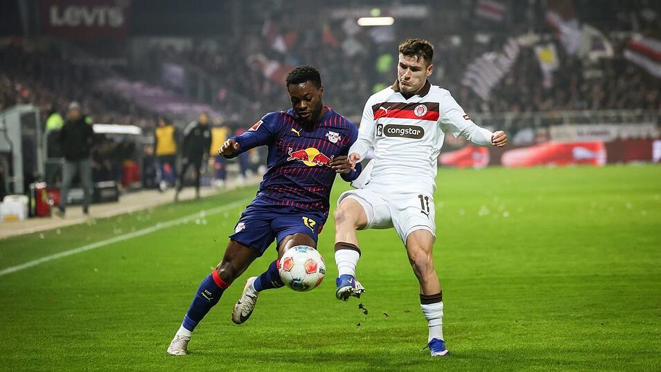 Leipzigs Ridle Baku (l) und St. Paulis Arkadiusz Pyrka k&auml;mpfen um den Ball.