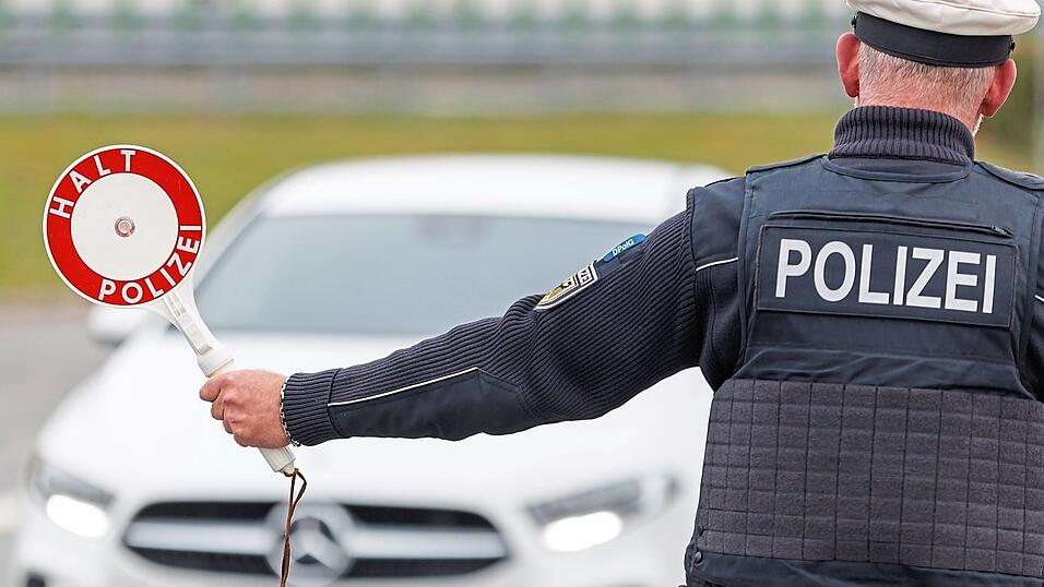 Ein Polizei winkt an der Grenze ein Auto heraus.