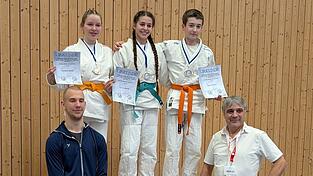 Die Wallersdorfer K&auml;mpfer (hinten v.l.) Sabrina Grumm, Leyla Akg&uuml;n und Niklas Weise mit Daniel Hartock (l.) und JJSC-Trainer und -Vorsitzenden Lothar Lehermeier.