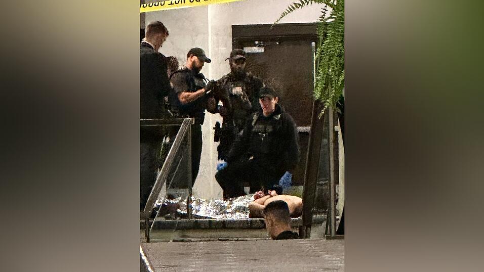 Sicherheitskr&auml;fte umringten eine am Boden liegende Person.