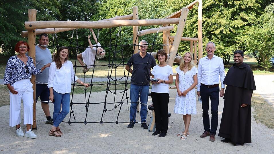 Weihten den Spielplatz ein (von links): Cristina Pop, Tiefbauamtsleitung, Stefan M&uuml;ller, Stadtg&auml;rtnerei, Anna S&uuml;&szlig;, Leiterin Abteilung Jugendarbeit, J&ouml;rg B&auml;r, Leiter der Stadtg&auml;rtnerei, Pfarrerin Christine Riesbeck von der Christuskirche, Verwaltungsr&auml;tin Katharina Dilger, Oberb&uuml;rgermeister Markus Pannermayr, Karmeliten-Pater Anil John Kaipranpadan. Das Kletterger&uuml;st kommt bei den Kindern bereits sehr gut an - wie auf dem Bild zu sehen ist.