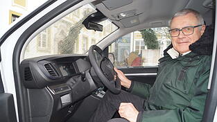 Josef Maier bei einer Sitzprobe hinter dem Lenkrad.