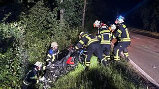 Einsatzkr&auml;fte der FFW hoben nach dem Unfall das Motorrad&nbsp;h&auml;ndisch aus der B&ouml;schung.