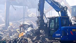 Einsatzkräfte des Technischen Hilfswerks (THW) beseitigen mit einem Bagger Schutt nach einem Feuer in einem Gewerbegebiet in Stuttgart. Einsatzkräfte des Technischen Hilfswerks (THW) beseitigen mit einem Bagger Schutt nach einem Feuer in einem Gewerbegebiet in Stuttgart.