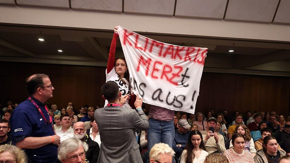 Klimaaktivisten st&ouml;ren mehrere Minuten lang die Podiumsdiskussion mit Merz.