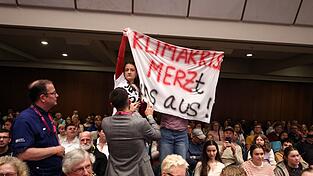 Klimaaktivisten st&ouml;ren mehrere Minuten lang die Podiumsdiskussion mit Merz.