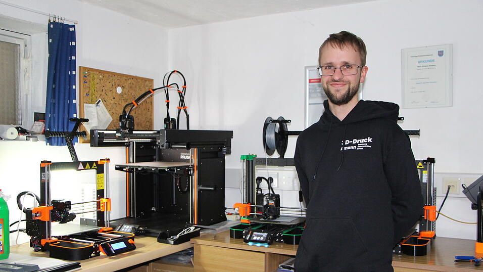 'Das Coole ist: Ist was kaputtgegangen, druckt man es einfach neu', findet Florian Amann. Links neben ihm fertigt ein 3D-Drucker eine graue PlayStation-Halterung. Der Werkstoff - meistens PLA - kommt auf Spulen bei Amann an und wird auf 215 Grad Celsius erhitzt. Schicht für Schicht entsteht das gewünschte Produkt. 'Das Coole ist: Ist was kaputtgegangen, druckt man es einfach neu', findet Florian Amann. Links neben ihm fertigt ein 3D-Drucker eine graue PlayStation-Halterung. Der Werkstoff - meistens PLA - kommt auf Spulen bei Amann an und wird auf 215 Grad Celsius erhitzt. Schicht für Schicht entsteht das gewünschte Produkt.