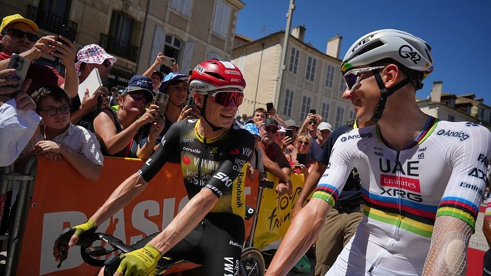 Der Däne Jonas Vingegaard (l) und der Slowene Tadej Pogacar (r) unterhalten sich vor dem Start. Der Däne Jonas Vingegaard (l) und der Slowene Tadej Pogacar (r) unterhalten sich vor dem Start.