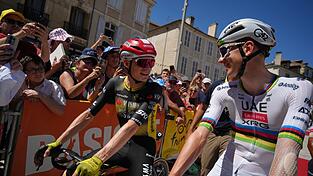 Der Däne Jonas Vingegaard (l) und der Slowene Tadej Pogacar (r) unterhalten sich vor dem Start.