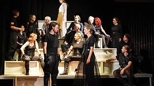 Macbeth (Aaron Jungblut-Klemm) und Lady Macbeth (Gabi Butz) in der vordersten Bildebene mit den anderen schottischen Adligen und Bediensteten im Hintergrund Macbeth (Aaron Jungblut-Klemm) und Lady Macbeth (Gabi Butz) in der vordersten Bildebene mit den anderen schottischen Adligen und Bediensteten im Hintergrund