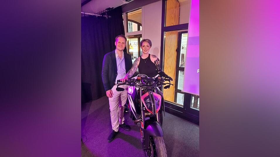 Professor Silvan Eisenmann und Janine Piller mit ihrem neuen Motorrad, einer KTM 1290 Super Duke, und der schwarzen Prothese.