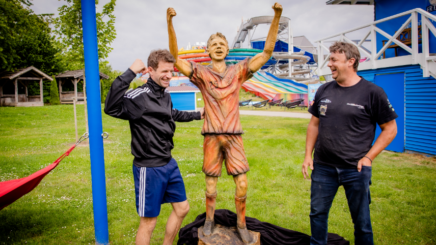Fußballprofi Thomas Müller (links) freut sich über die Holzskulptur, die Sven Wastian in Handarbeit geschaffen hat. Fußballprofi Thomas Müller (links) freut sich über die Holzskulptur, die Sven Wastian in Handarbeit geschaffen hat.