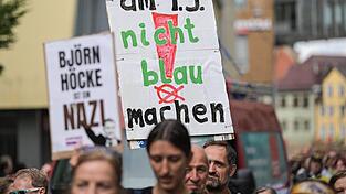 Am Rande der Wahlkampfveranstaltung halten Demonstranten Schilder gegen Rechts in die Luft.