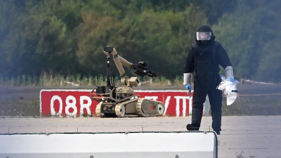 Ein Kriminaltechniker ist neben einem Sprengroboter in der N&auml;he eines ukrainischen Flugzeugs auf dem Flughafen Leipzig/Halle im Einsatz. Der Vorfall vergangene Woche hat eine erneute Debatte &uuml;ber den Einsatz der Bundeswehr im Inneren ausgel&ouml;st.