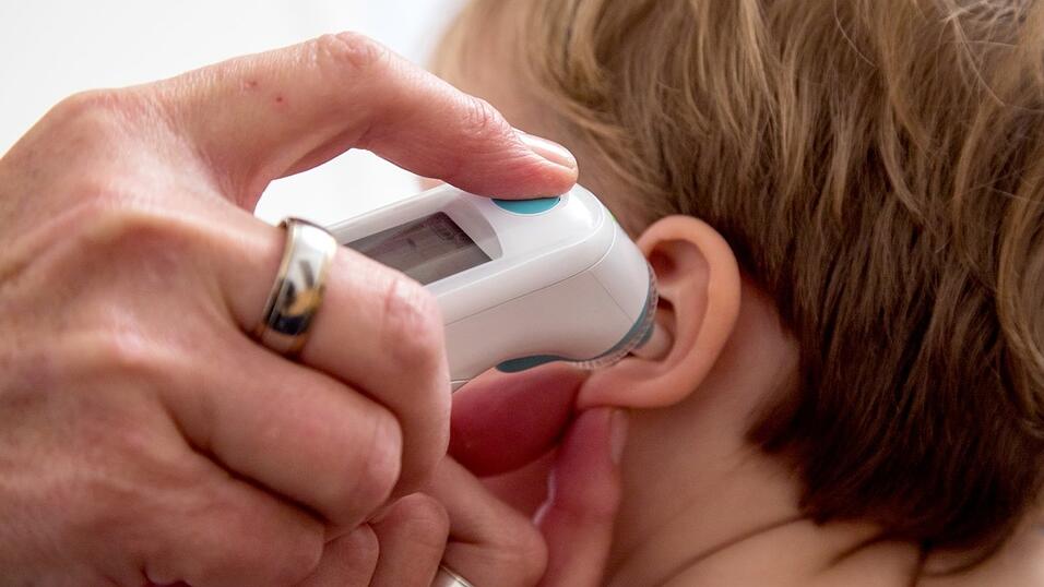 Bei einem Kind wird die Temperatur gemessen. In mehreren europäischen Ländern sind bei Kindern ungewöhnlich schwere Erkrankungen festgestellt worden, darunter in Deutschland.