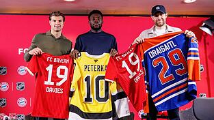Fu&szlig;ball und Eishockey als Partner: Die deutschen Eishockeystars John-Jason Peterka (l) und Leon Draisaitl (r) mit dem kanadischen Bayern-Profi Alphonso Davies.