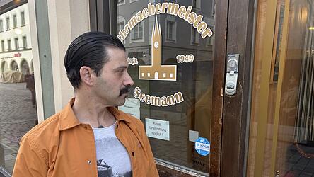 Andreas Seemann schaut auf die Hebelspuren an der Holzt&uuml;r zu seinem Laden im Stadtturm.